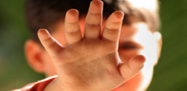 boy with hand in front of his face for sexual abuse awreness